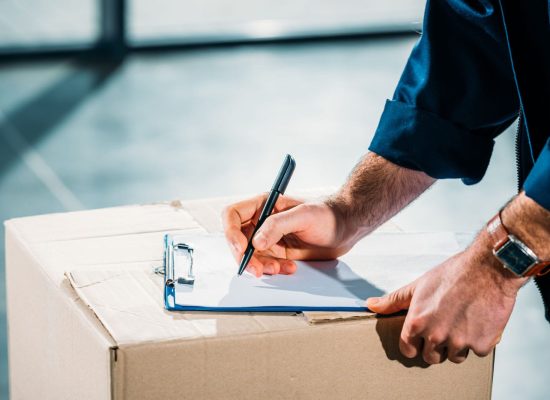 Courier filling cargo declaration on cardboard package Courier filling cargo declaration on cardboard package